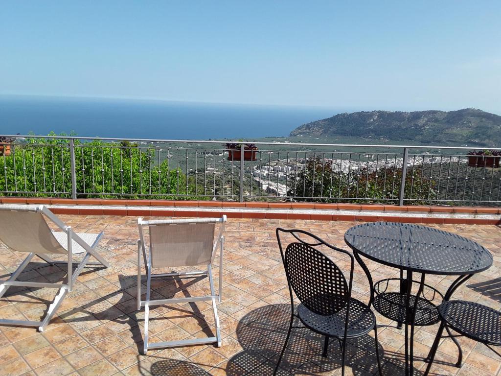 a patio with three chairs and a table with a view at B&B La Scapola in Mattinata