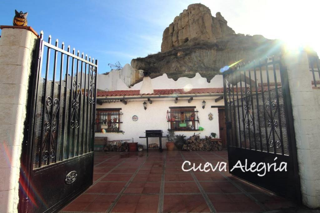 a gate to a building with a mountain in the background at cueva alegria in Guadix