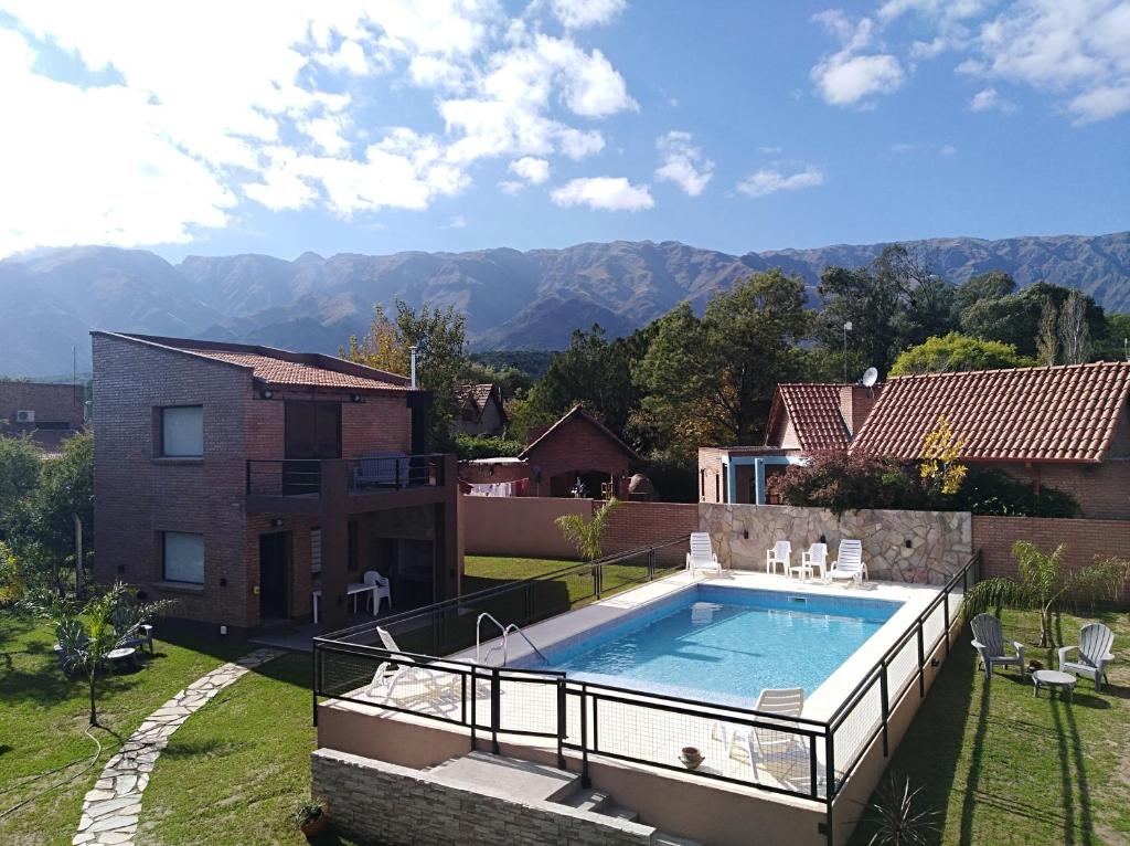 una piscina en un patio trasero con montañas al fondo en Cabañas Loma Maluc en Merlo