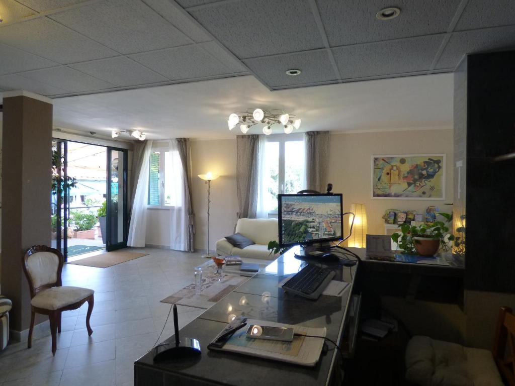 a living room with a desk with a computer on it at Hotel Turandot in Torre del Lago Puccini