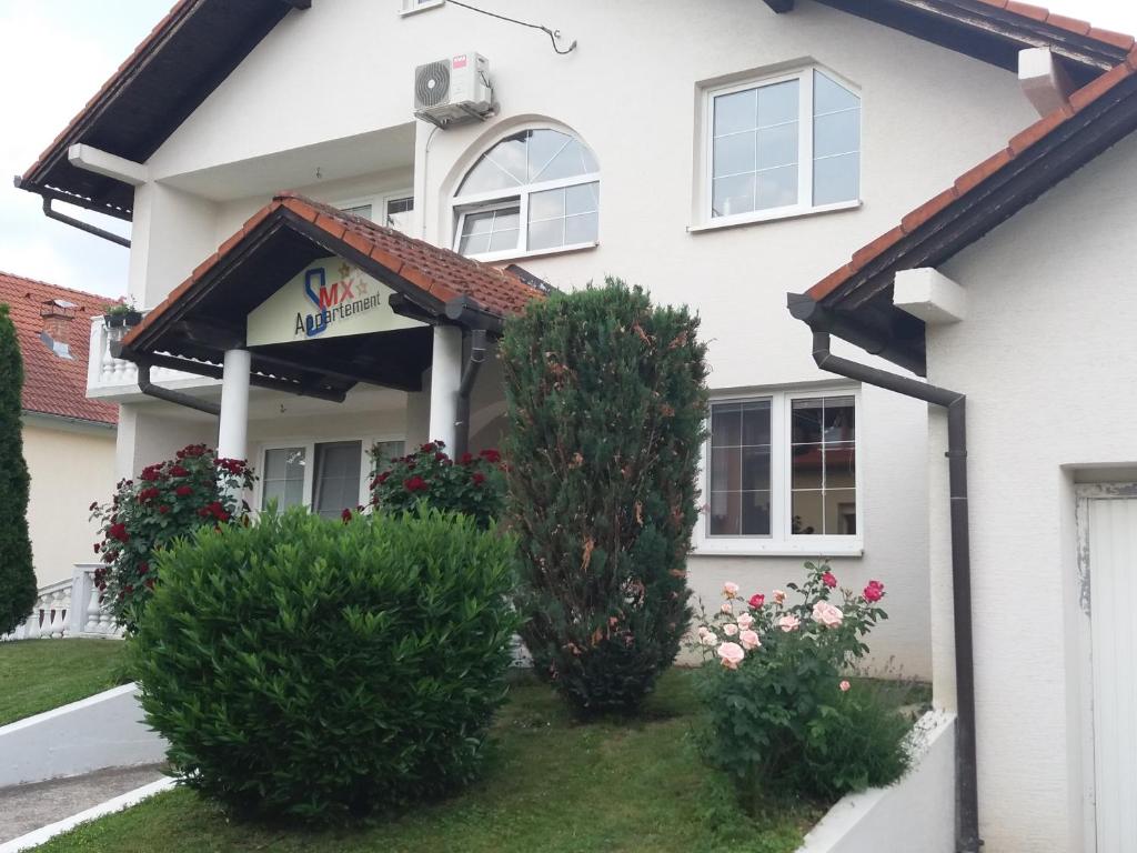 Biały dom z dwoma krzakami przed nim w obiekcie Smx Apartement w mieście Prelog