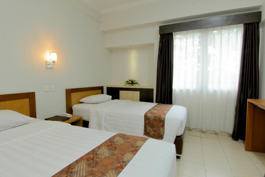 Postel nebo postele na pokoji v ubytování University Hotel Yogyakarta