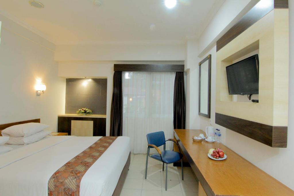 Postel nebo postele na pokoji v ubytování University Hotel Yogyakarta