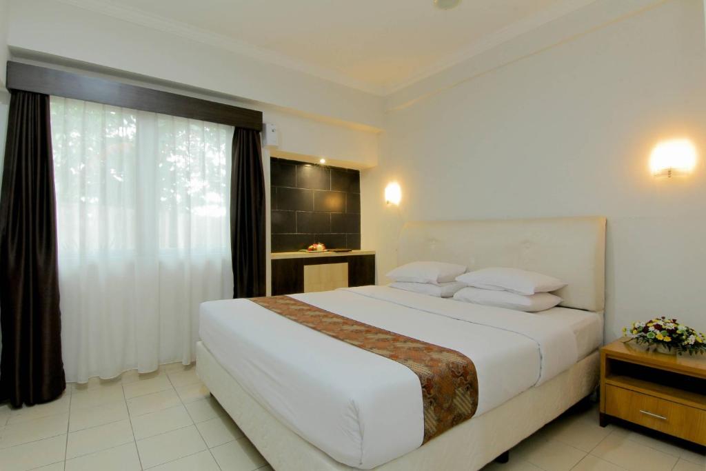 Postel nebo postele na pokoji v ubytování University Hotel Yogyakarta