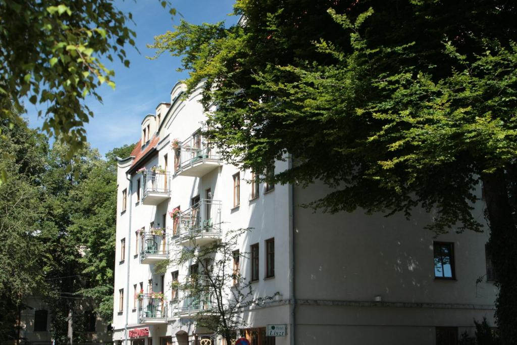 a white building with balconies on a street at Hotel Liszt in Weimar