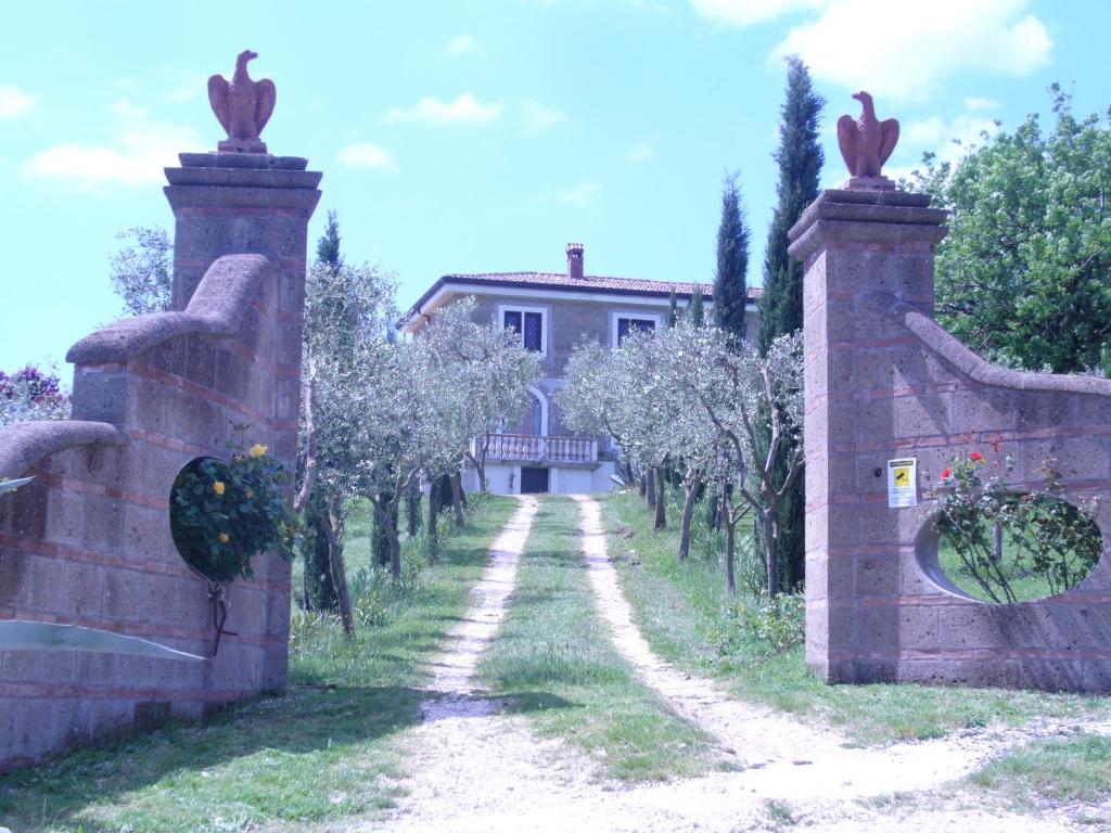 einen Steinzaun mit einem Weg zum Haus in der Unterkunft Casale Nido dell'Aquila in Squille