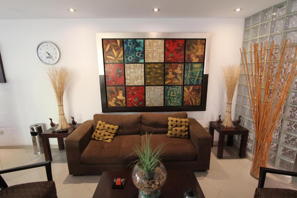una sala de estar con sofá y una pintura en la pared en Hotel Chicama, en Trujillo