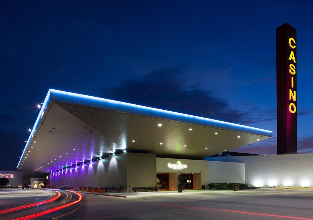 een verlicht gebouw met 's nachts een bord bij Cypress Bayou Casino Hotel in Franklin