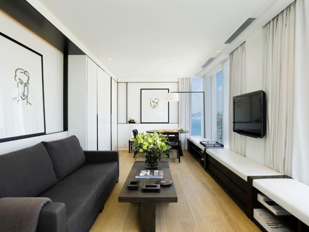 a living room with a couch and a tv at The Jervois in Hong Kong