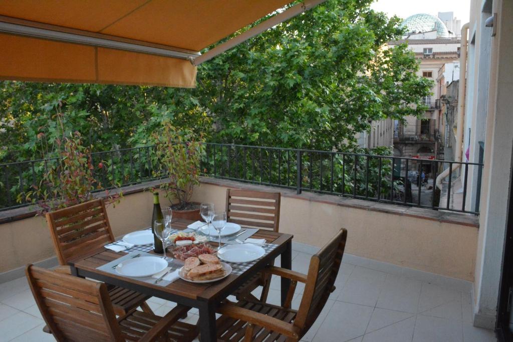 une table avec des assiettes de nourriture sur un balcon dans l'établissement Apartament La Placeta Figueres, à Figueres