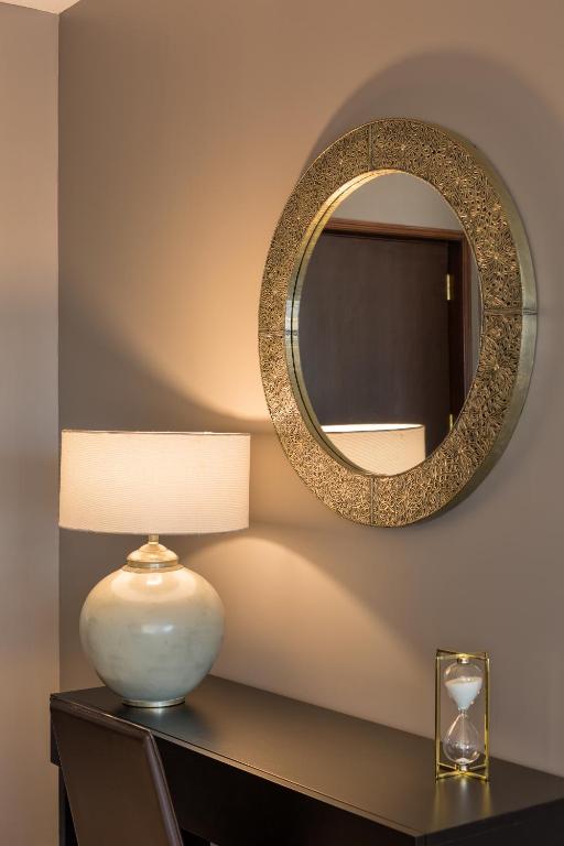 a table with a lamp and a mirror on a wall at AP Oriental Beach - Adults Friendly in Portimão