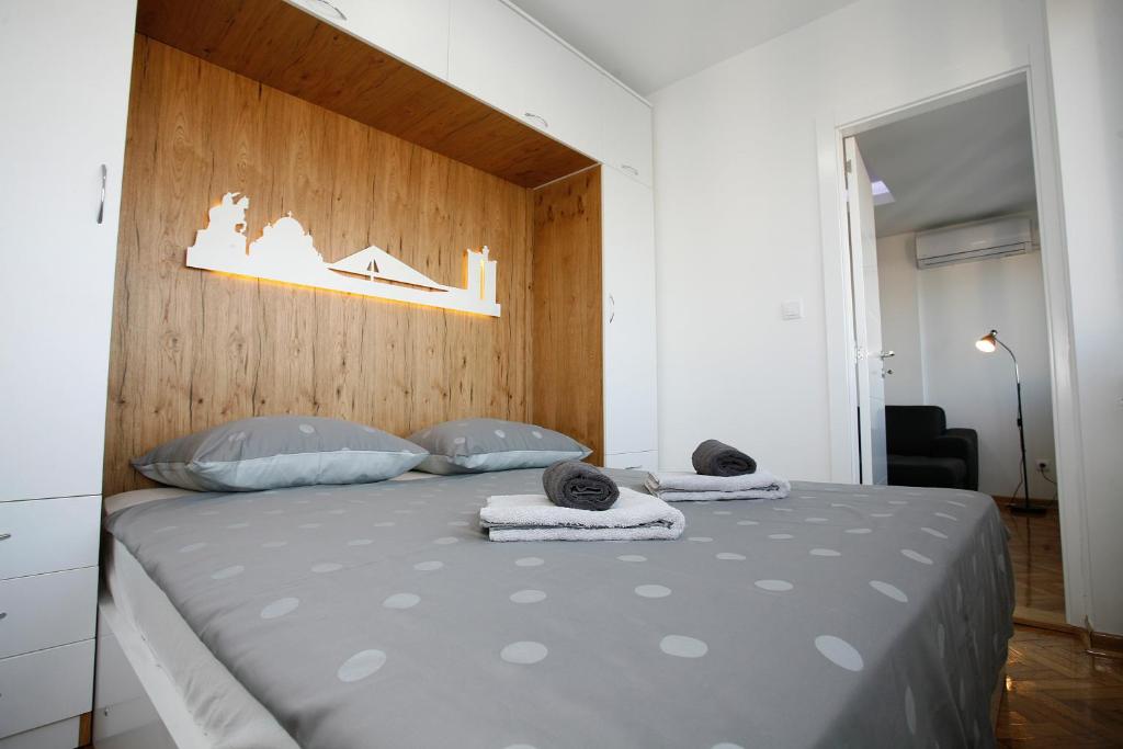 a bedroom with a large bed with a wooden headboard at White Lux apartment in Belgrade