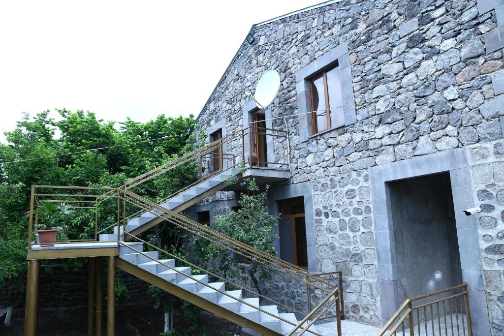 a stone building with a staircase on the side of it at Mthnadzor in Goris