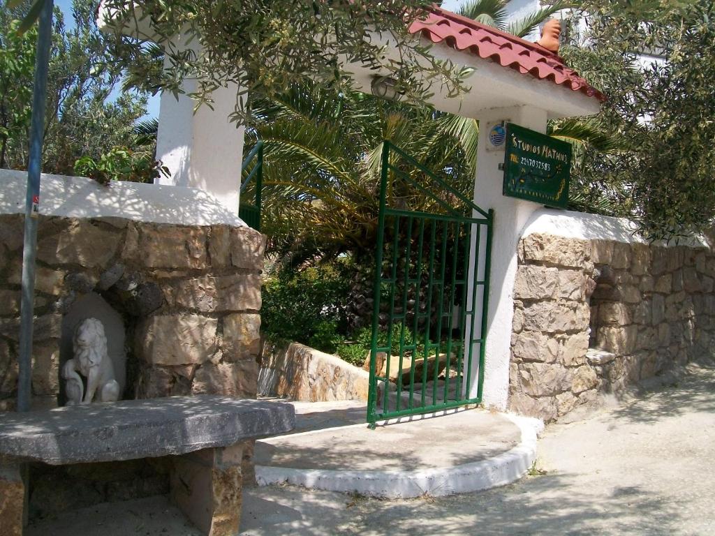un edificio con una puerta y un banco de piedra en PATMOS Mathios Studios- apartments, en Patmos