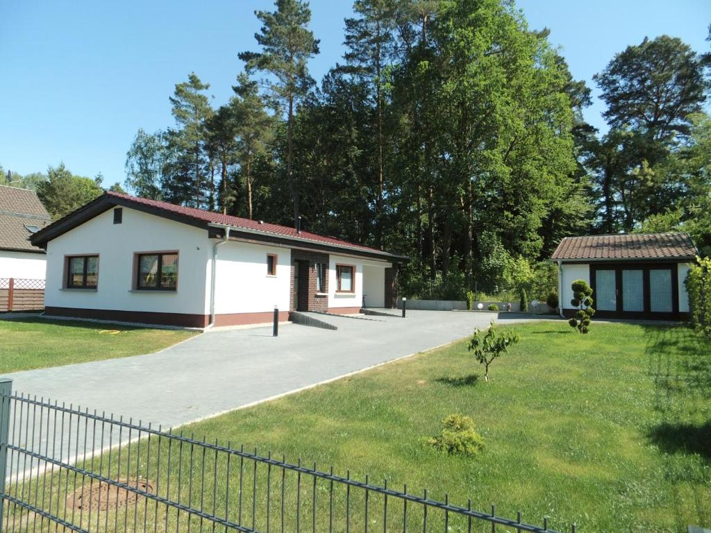 uma casa com uma cerca em frente a um quintal em Sidowseetraum em Himmelpfort