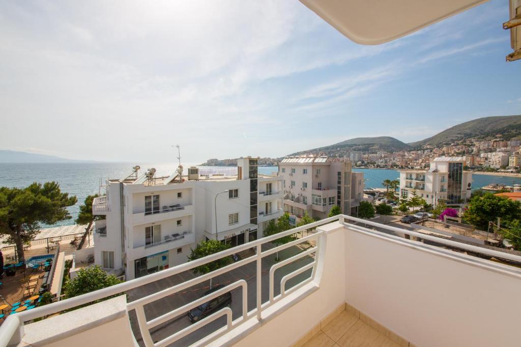 balcón con vistas al océano y a los edificios en Hotel Alina, en Sarandë