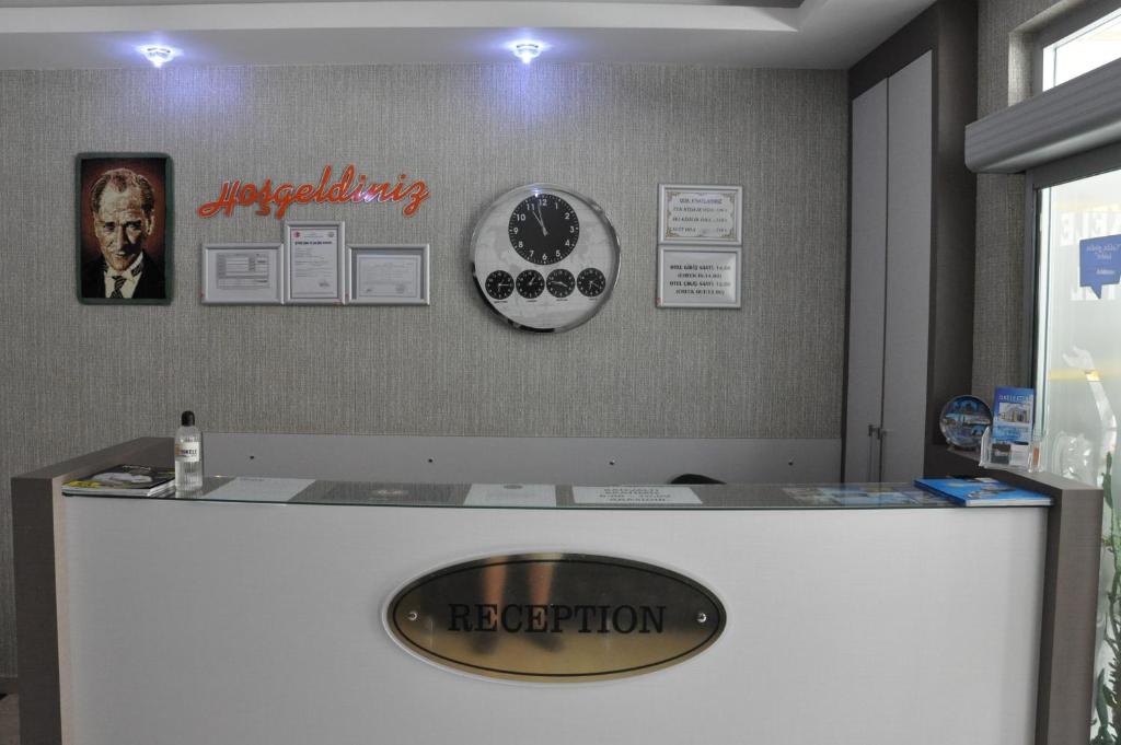 a reception desk with a sign on the wall at İskele Otel in Tasucu
