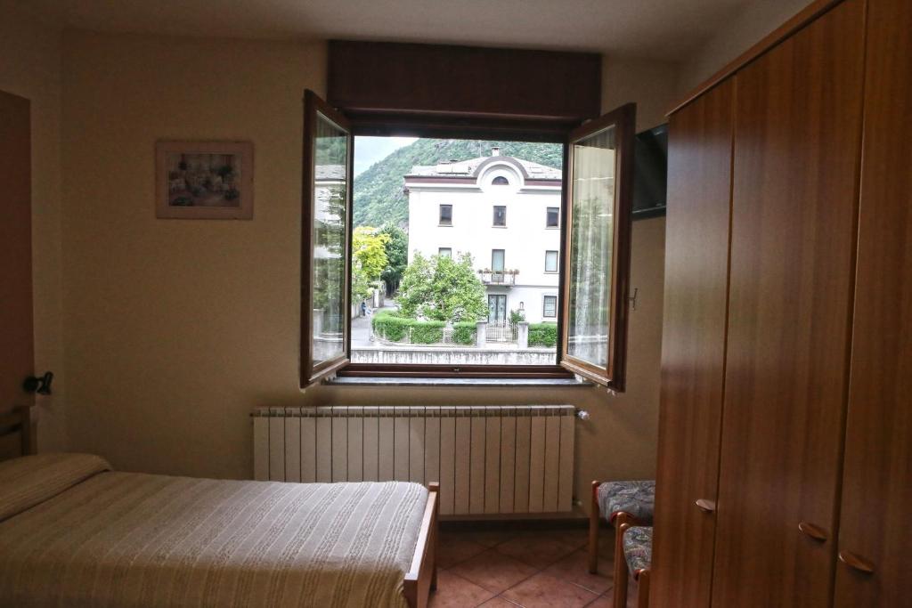 sypialnia z łóżkiem i dużym oknem w obiekcie Albergo Gusmeroli w mieście Tirano