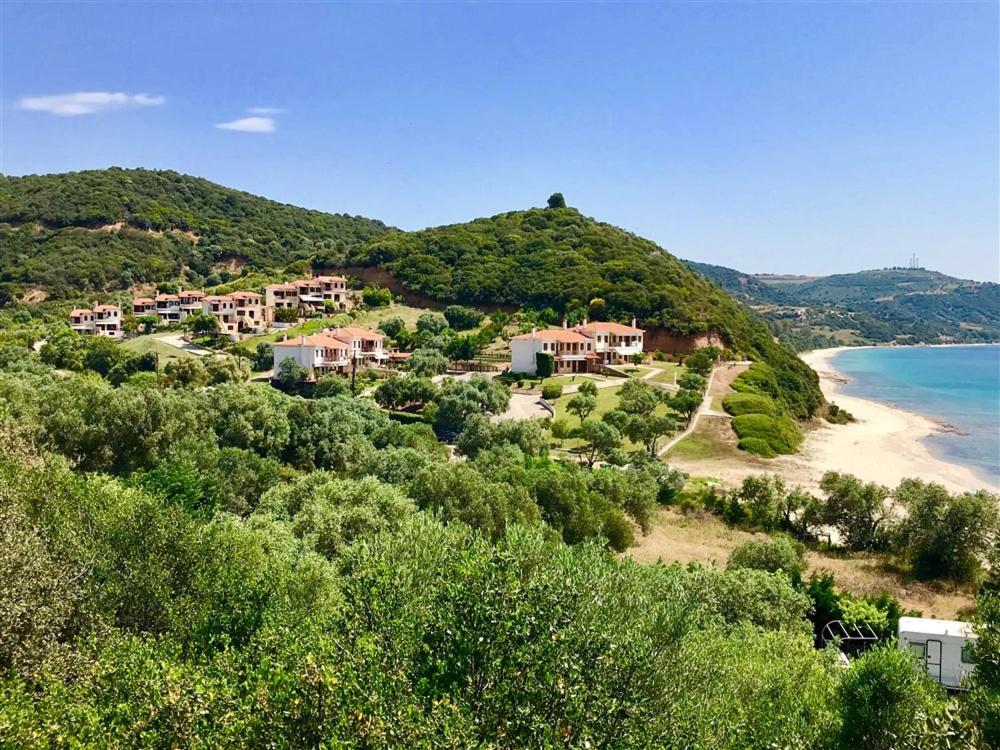 a resort on a hill next to the beach at Chalkidiki Develiki Villas in Develíkia