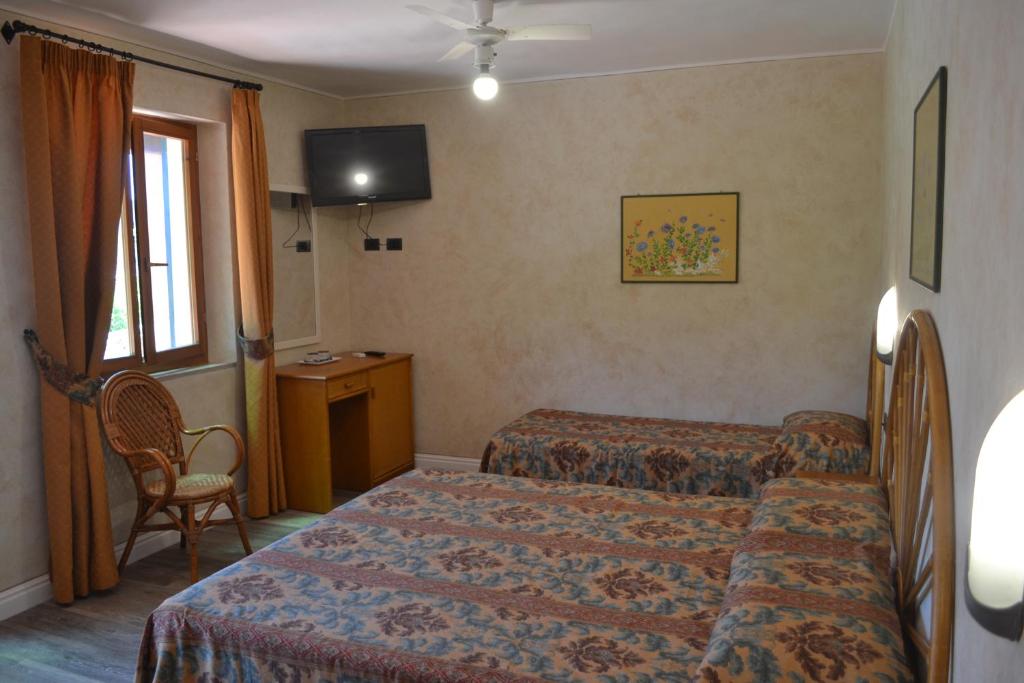 a hotel room with two beds and a tv at Hotel Danila in Portoferraio