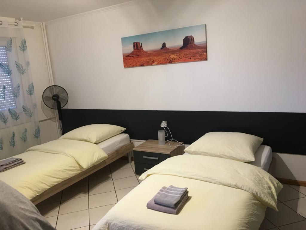 Zimmer mit 2 Betten und einem Bild an der Wand in der Unterkunft Studio Lora RM 1221 in Saint-Louis