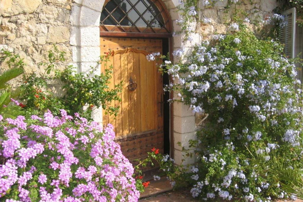 una porta in legno con fiori di fronte a un edificio di Chambres d'hôtes Il Monticello a Grasse