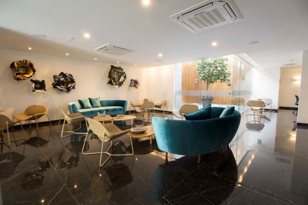 a lobby with blue couches and tables and chairs at Tierra Viva Miraflores Mendiburu in Lima