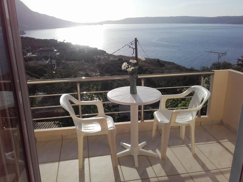 uma mesa e cadeiras numa varanda com vista para o oceano em Olympic View Guesthouse em Kalami