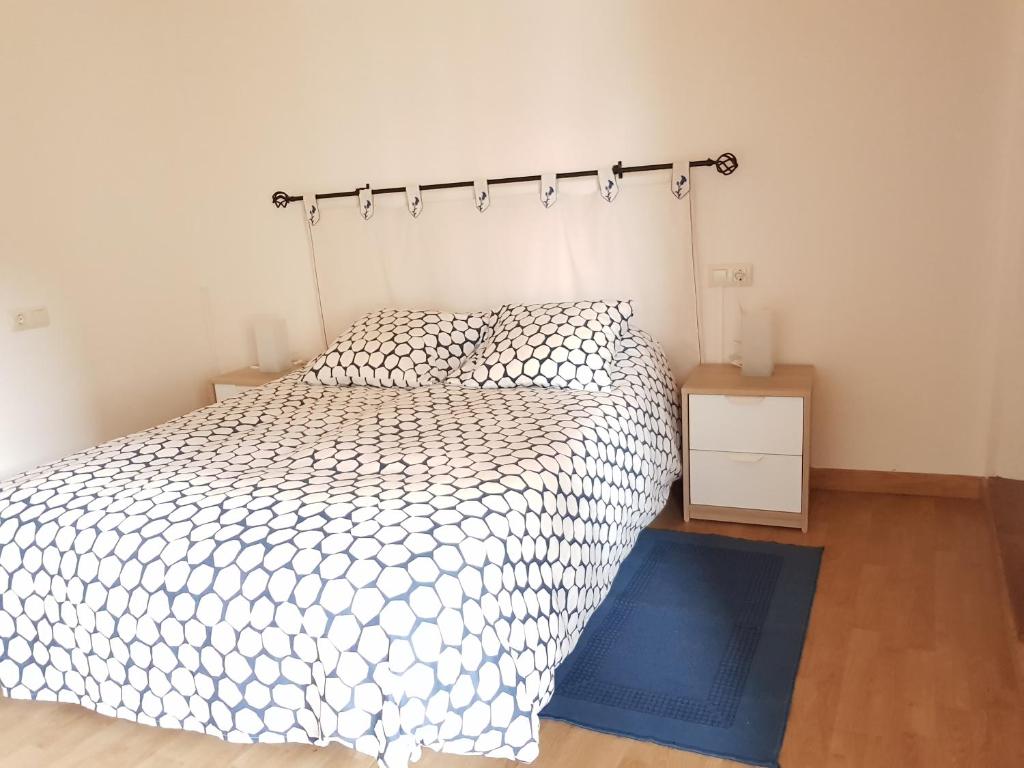 een slaapkamer met een wit bed en een blauw tapijt bij Casa García in Allariz