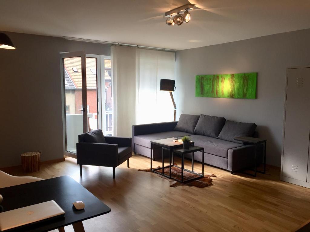 ein Wohnzimmer mit einem Sofa und einem Tisch in der Unterkunft 21st Appartement in Düsseldorf