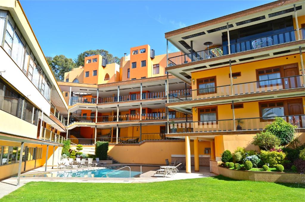 an apartment building with a swimming pool and a yard at Hotel Lastra in Puebla