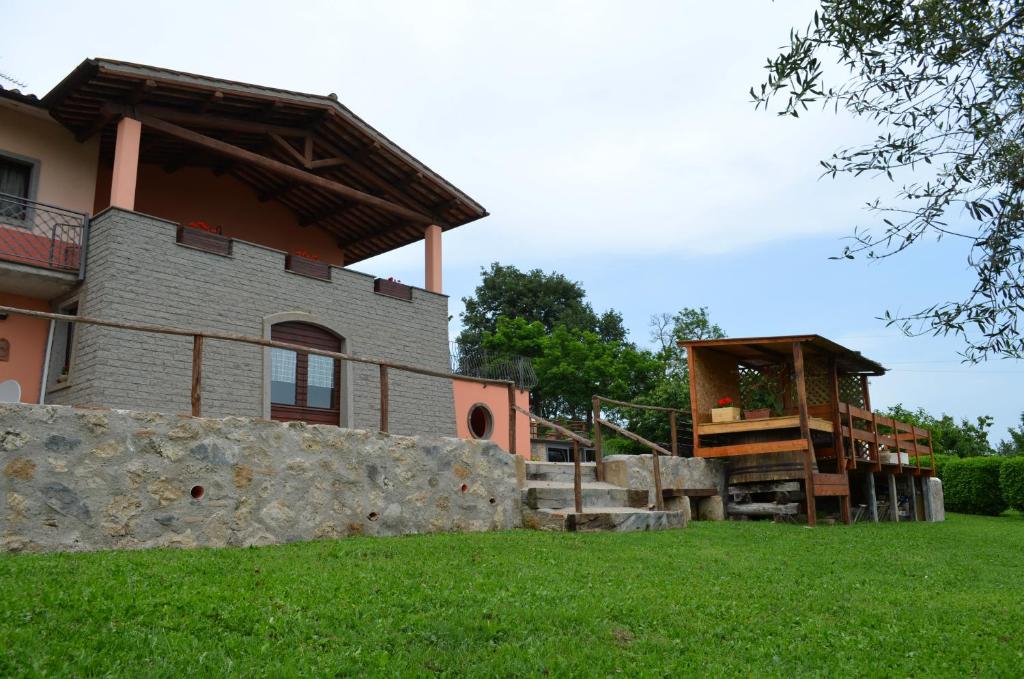 a house with a stone retaining wall and a porch at Bed and Breakfast Bike in Bagnoregio