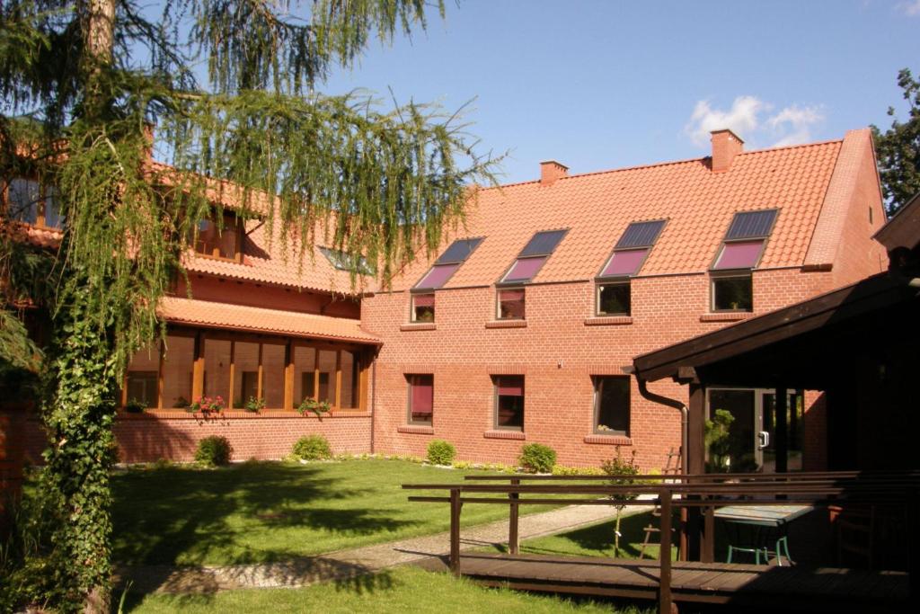 un bâtiment en brique rouge avec des panneaux solaires dans l'établissement Hotel Belfer, à Zaniemyśl