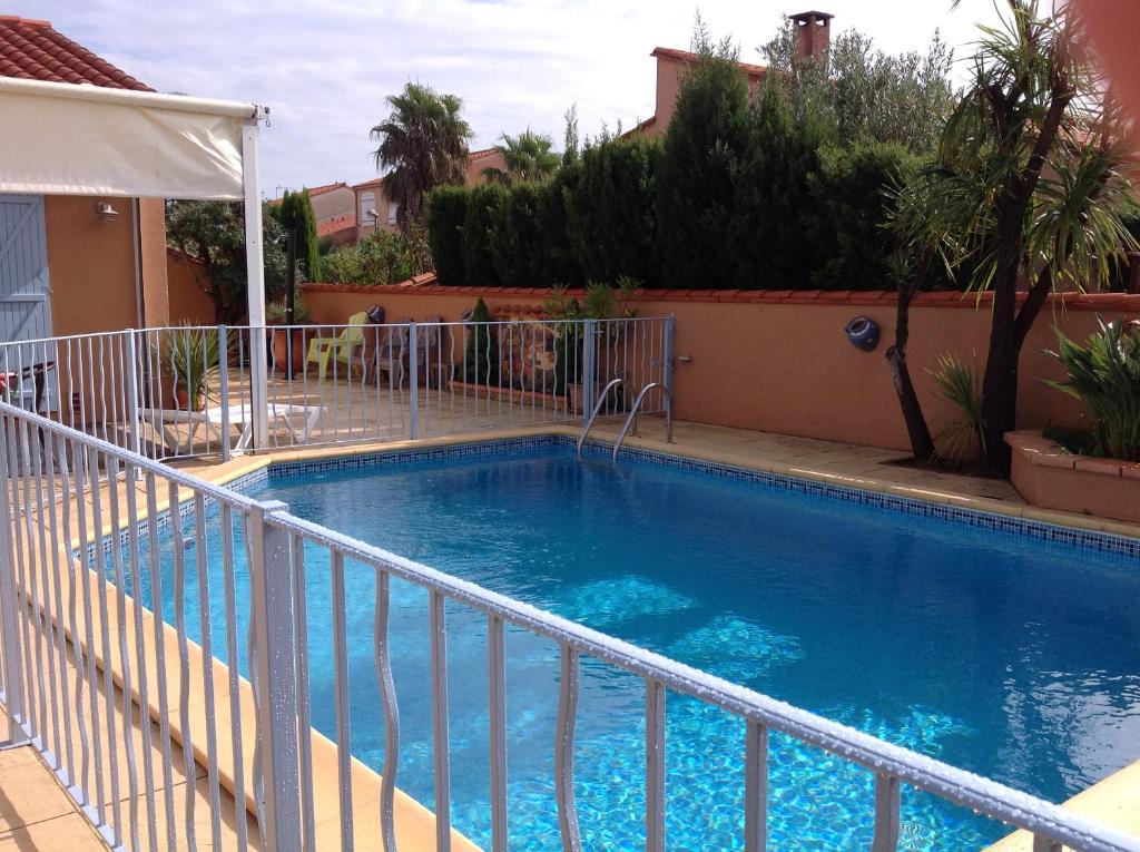 une grande piscine bleue avec une clôture blanche dans l'établissement Bord de mer villa 8pers piscine au sel chauffée, à Saint-Cyprien