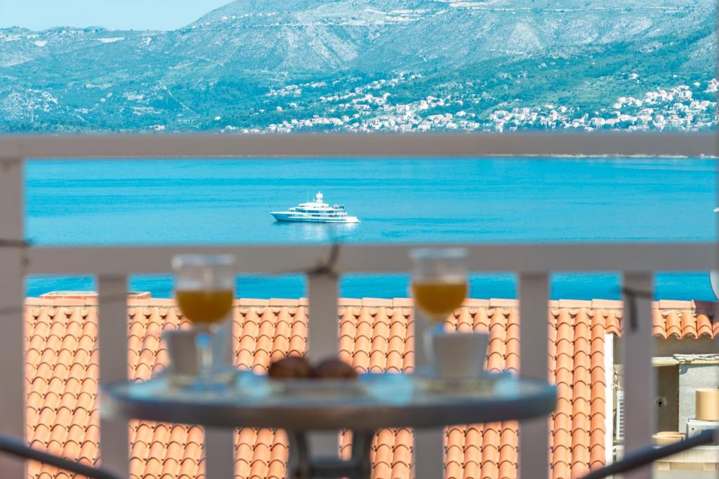 ein Boot auf dem Wasser mit Balkon mit zwei Getränken in der Unterkunft Villa Nick in Cavtat
