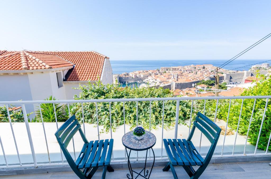 duas cadeiras e uma mesa numa varanda com o oceano em Apartments A&M em Dubrovnik