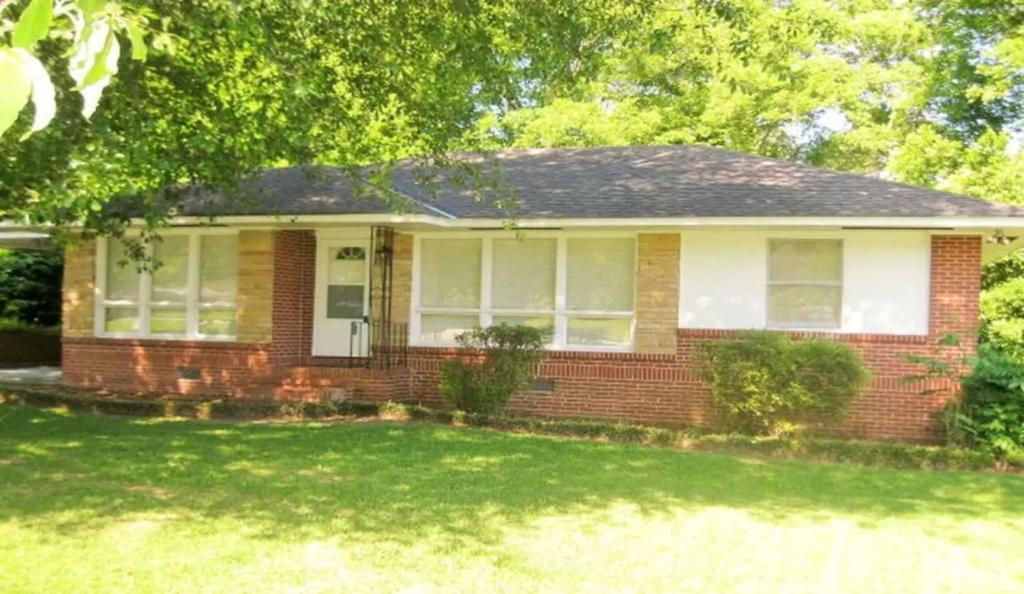 a red brick house with a tree in the yard at The Pineapple Lady 13min to Fort Benning in Columbus