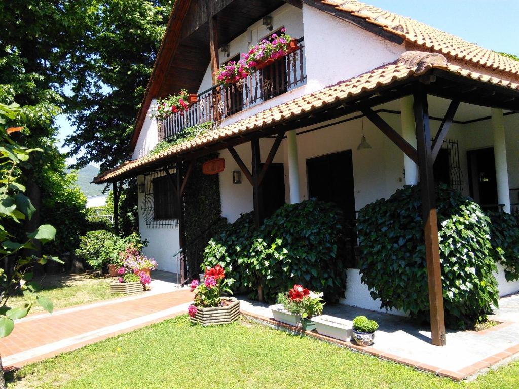 uma casa com uma varanda com flores em Villa Afroditi em Nea Vrasna