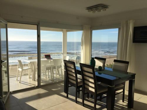 a dining room with a view of the ocean at Pinamar Alquilo Departamentos Frente Al Mar in Ostende