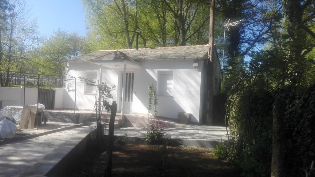 een klein wit huis midden in een tuin bij Casa Castrelo in Retorta