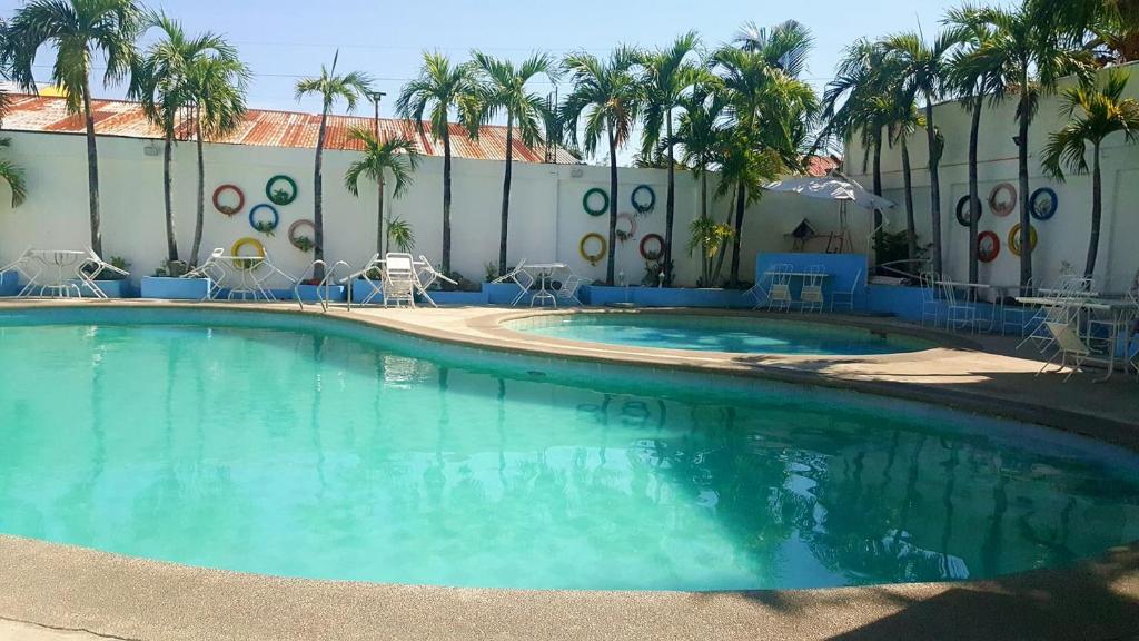 una gran piscina frente a un edificio con palmeras en The Palacio de Laoag, en Laoag