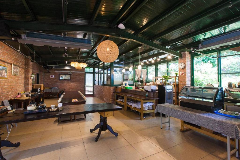 uma grande sala com mesas e bancos num restaurante em Locasu em Datong