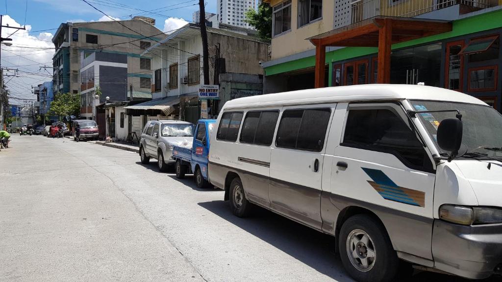 a white van parked on the side of a street at Crossroads Hostel Manila in Manila