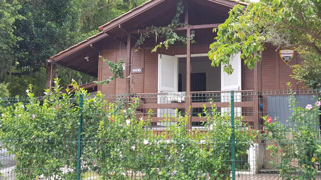 une maison brune avec une clôture devant elle dans l'établissement Casa Praia da Lagoinha, à Florianópolis