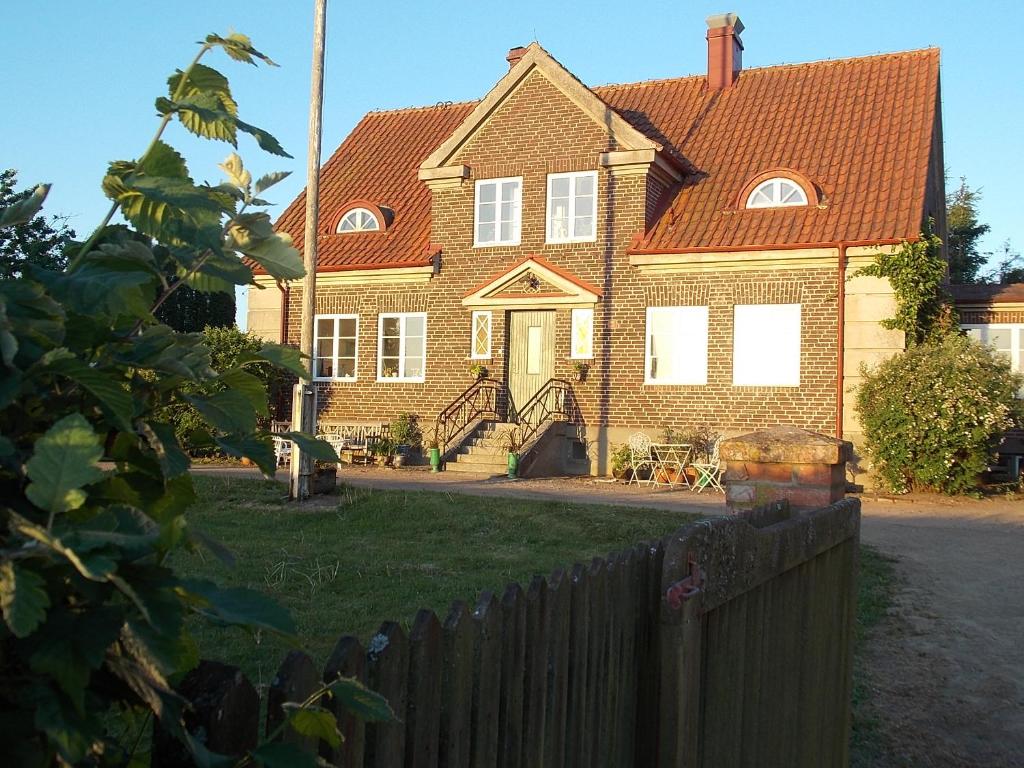 ein Backsteinhaus mit einem Zaun davor in der Unterkunft The Garden Hill Hotel in Vallåkra