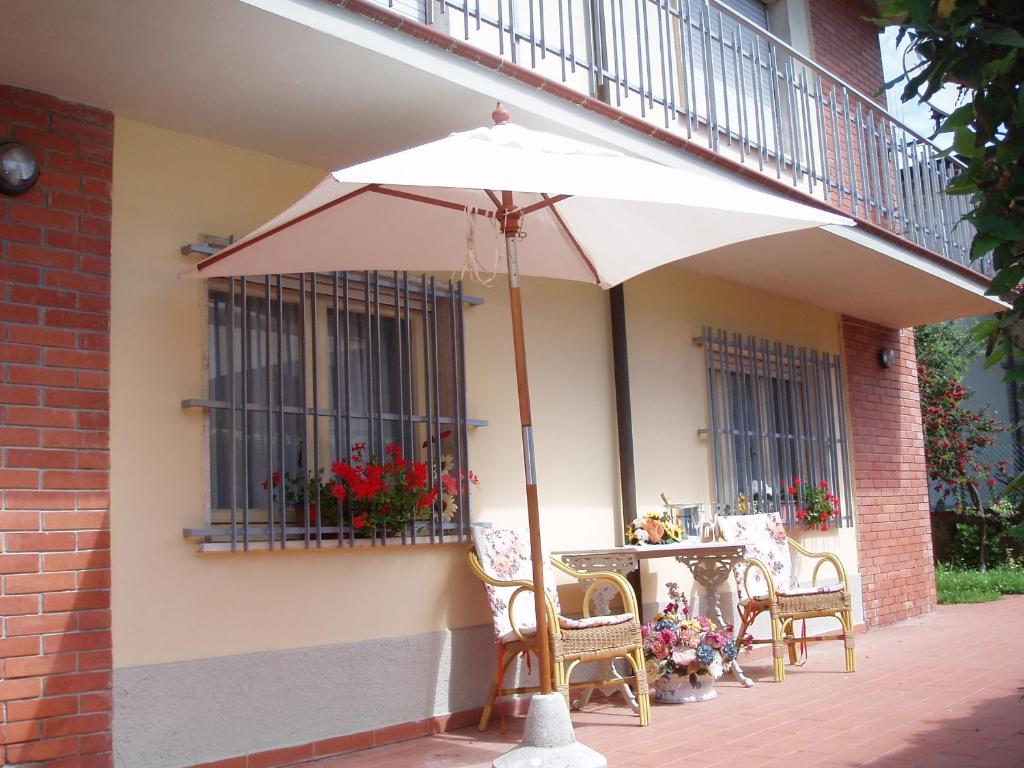 patio con ombrellone, sedie e tavolo di Casa Giuseppina a Camaiore