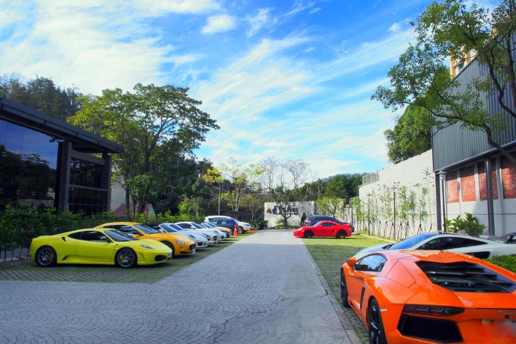 a row of expensive cars parked next to a building at Fuli Hot Spring Resort in Yuchi
