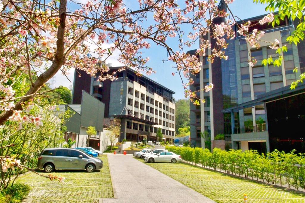 a street with cars parked in front of buildings at Fuli Hot Spring Resort in Yuchi