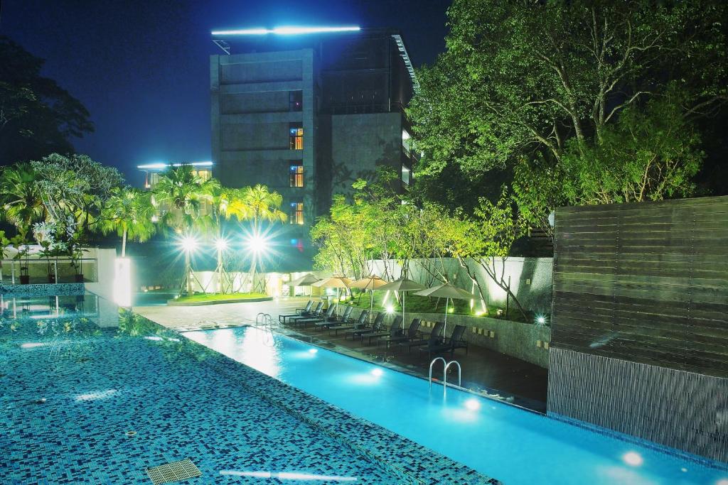 a swimming pool at night with a building in the background at Fuli Hot Spring Resort in Yuchi