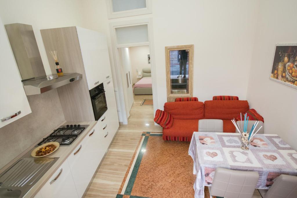 uma cozinha e uma sala de estar com um sofá vermelho em Al Vecchio Fontanile em Lesina
